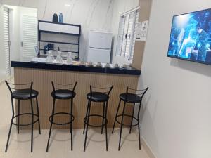 a bar with four black stools in a kitchen at Pousada Do Goiano in Manhã +22 photos