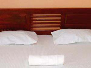two white pillows are sitting on a bed at Ceylon Salt & Soul in Arugam Bay