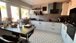 a kitchen with white cabinets and a table with fruit on it at Peaceful Coastal Escape in Old Colwyn