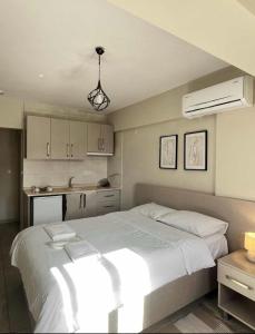 a bedroom with a large white bed and a kitchen at Rain Suite in Istanbul