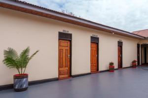 a building with wooden doors and a potted plant at Elikai Hostels 