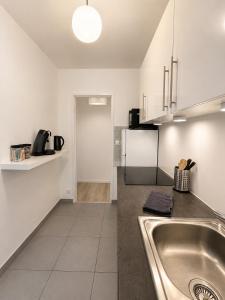 a kitchen with a sink and a counter top at LorOtel - Frontiere - Aeroport in Saint-Louis +23 photos