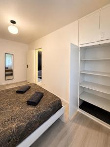 a bedroom with a bed with two black pillows on it at LorOtel - Frontiere - Aeroport in Saint-Louis