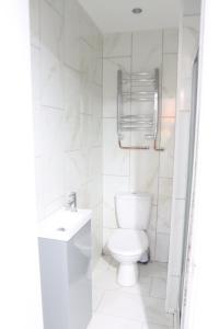 a white bathroom with a toilet and a sink at Upton House in Chatham +8 photos