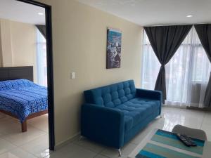 a blue couch in a room with a bed and a mirror at Beautiful, comfortable and functional apartment 4 in Guadalupe