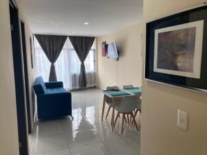 a living room with a blue chair and a table at Beautiful, comfortable and functional apartment 4 in Guadalupe +21 photos