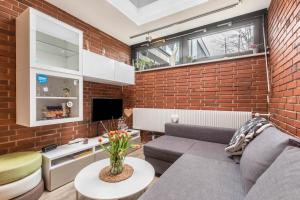 a living room with a couch and a brick wall at Ferienwohnung Stillblick in Gersthofen