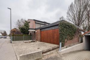 a brick house with a wooden gate on a street at Ferienwohnung Stillblick in Gersthofen