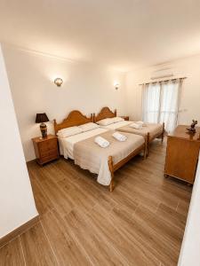 a bedroom with two beds and a wooden floor at Casa Mar by Living & Co in Albufeira +15 photos