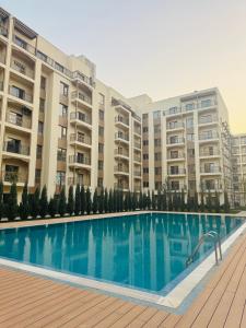 a swimming pool in front of some apartment buildings at Чарвак дарвозаси люкс апартамент, дом в горах с видом in Khŭjakent