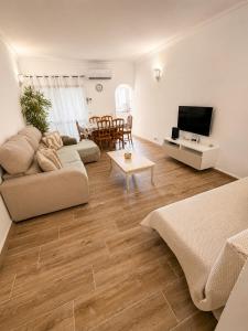 a living room with a couch and a tv at Casa Mar by Living & Co in Albufeira