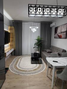 a living room with a couch and a table at Чарвак дарвозаси люкс апартамент, дом в горах с видом in Khŭjakent