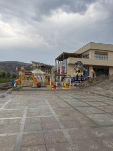 a playground in front of a building with a water park at Чарвак дарвозаси люкс апартамент, дом в горах с видом in Khŭjakent