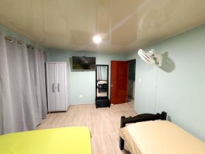 a bedroom with a yellow bed and a mirror at posada nativa NIYKA in Casabaja