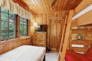 a bedroom with a bunk bed and a tv at Four Seasons at the Lake in Bridgton