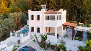 an aerial view of a white house with a swimming pool at Villa Sea View Gem Steps to Zia Square Hot Tub in Lagoúdi Zía
