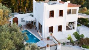 an aerial view of a white house with a swimming pool at Villa Sea View Gem Steps to Zia Square Hot Tub in Lagoúdi Zía