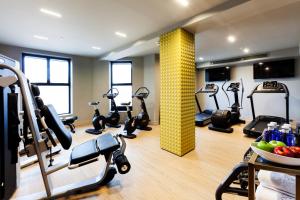 a gym with treadmills and elliptical machines at Barceló Emperatriz in Madrid