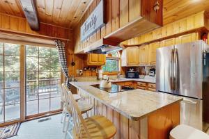 a kitchen with wooden cabinets and a stainless steel refrigerator at Four Seasons at the Lake in Bridgton