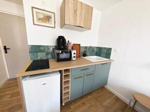 a small kitchen with blue cabinets and a counter top at L'oasis, studio hyper centre in Desvres