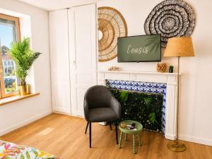 a living room with a chair and a fireplace at L'oasis, studio hyper centre in Desvres
