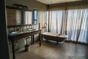 a bathroom with two sinks and a bath tub at Atamisque Wine Lodge - Valle de Uco in San José +37 photos