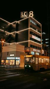 a bus parked in front of a building at night at くらしホテル Hakodate in Hakodate