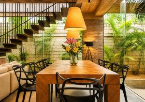 a table with chairs and a vase of flowers on it at Hum Living Luxury Villas in Tulum