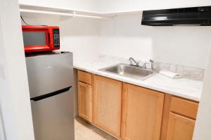 a small kitchen with a sink and a microwave at Solano Inn Vallejo Napa Valley - Six Flags in Vallejo