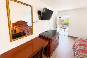 a bedroom with a bed and a dresser and a mirror at Solano Inn Vallejo Napa Valley - Six Flags in Vallejo