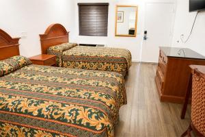 a hotel room with two beds and a dresser at Solano Inn Vallejo Napa Valley - Six Flags in Vallejo