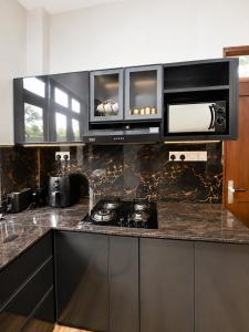 a kitchen with black cabinets and a counter top at The Oak Residence in Ragama
