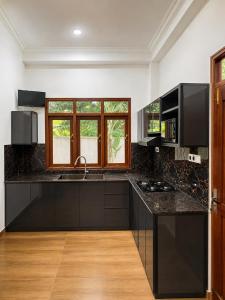 a kitchen with a black counter top and a window at The Oak Residence in Ragama +21 photos