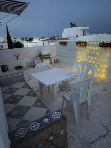 a white table and two chairs on a patio at honey moon zeinbe 4 in Hammamet