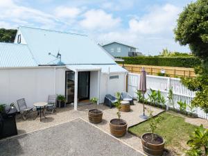 a backyard with plants and a white fence at Waimarama Coastal Getaway in Waimarama