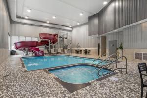 a pool with two chairs and a hot tub at Best Western Plus Dauphin in Dauphin
