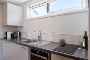 a kitchen counter with a sink and a window at Waimarama Coastal Getaway in Waimarama