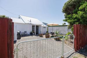 a gate to a backyard with a fence and an umbrella at Waimarama Coastal Getaway in Waimarama +17 photos