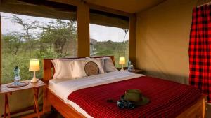 a bedroom with a bed with a camera on it at Royal Horizon Adventure in Sekenani