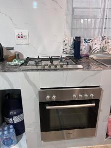 a stove top oven in a kitchen with a counter at Lynch Apartments 2 - Mimosa Chilanga in Lusaka