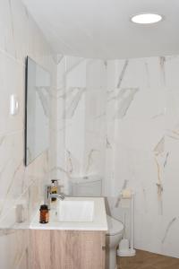 a white bathroom with a sink and a toilet at Casa dos Avós da Lapa in Lapa dos Dinheiros