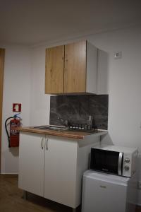a kitchen with white cabinets and a microwave at Casa dos Avós da Lapa in Lapa dos Dinheiros +7 photos