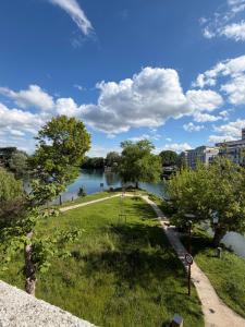 a view of a park with a river and buildings at Riverside Studio Joinville-Le-Pont in Joinville-le-Pont