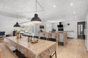 a large kitchen and dining room with a table and chairs at 8848-Hvide-Sande-Numitvej-9 in Hvide Sande