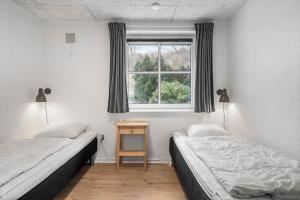 a bedroom with two beds and a window at 8848-Hvide-Sande-Numitvej-9 in Hvide Sande