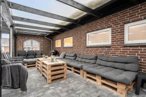 a living room with couches and a brick wall at 8848-Hvide-Sande-Numitvej-9 in Hvide Sande