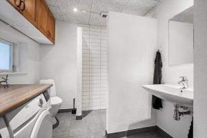 a white bathroom with a sink and a toilet at 8848-Hvide-Sande-Numitvej-9 in Hvide Sande +42 photos