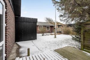 a yard with snow on the ground and a house at 8848-Hvide-Sande-Numitvej-9 in Hvide Sande
