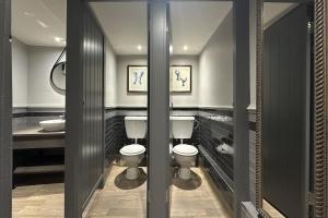 a bathroom with two toilets and a sink at Lobster Sheringham in Sheringham