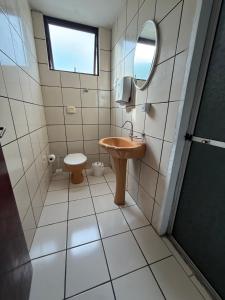 a bathroom with a sink and a mirror and a toilet at KITNETS Kretzer Hinckel 1 - CENTRO in Alfredo Wagner